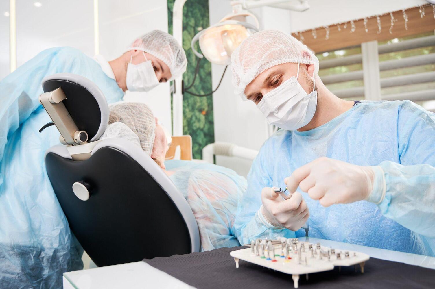 Dentist and his assistant working with a patient in a dentist chair in dentist office