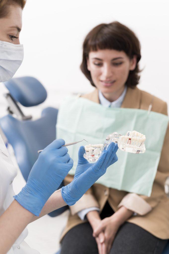 female-patient-looking-dental-mold-with-orthodontist
