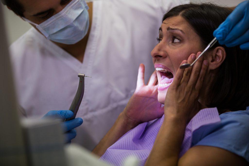 Female patient scared during a dental check-up in dental clinic