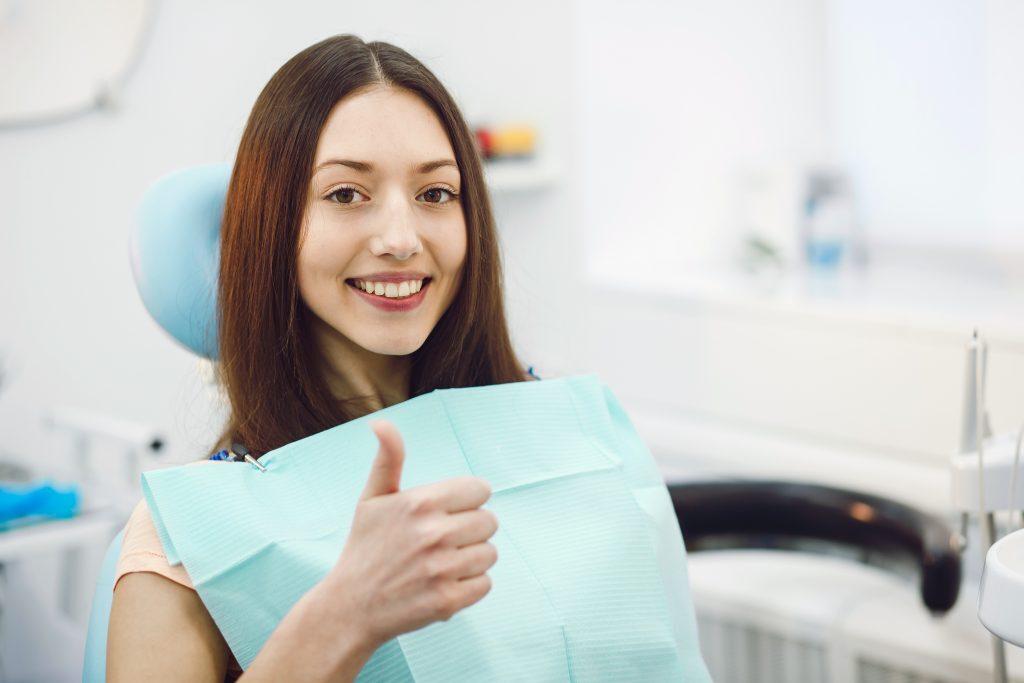 Girl showing thumbs up at a reception at the dentist