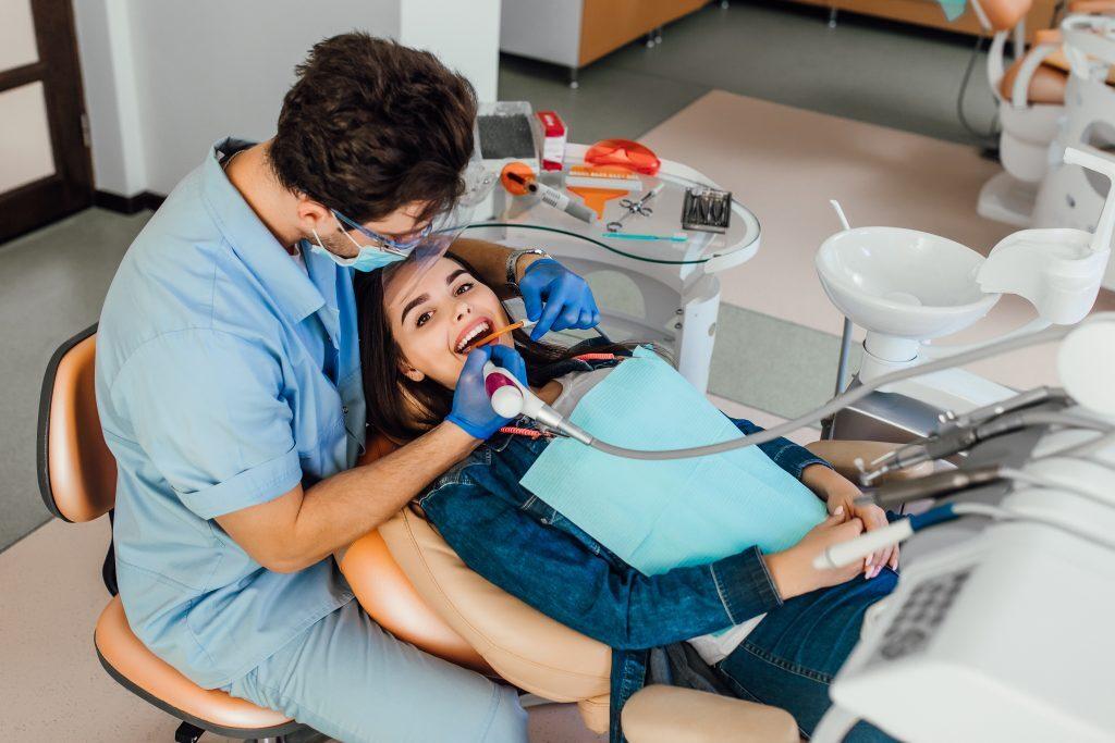 young-female-patient-with-open-mouth-examining-dental-inspection-dentist-office